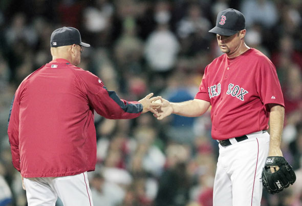 Tim Wakefield, right, hands the ball to manager Terry Francona while leaving the game in the fourth inning of a baseball game against the Kansas City Royals, Friday, May 28, 2010, in Boston.