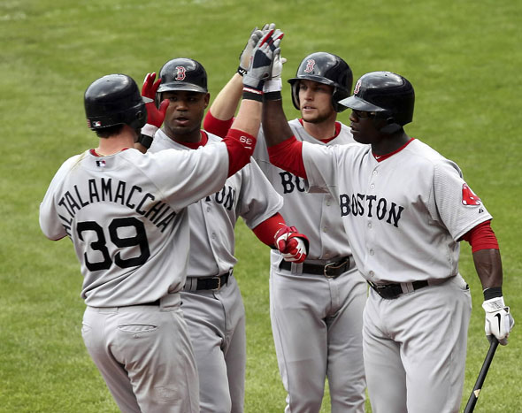 Jarrod Saltalamacchia is congratulated by teammates Carl Crawford, Jed Lowrie and Mike Cameron after hitting a three run home run during the sixth inning of the Red Sox MLB American League baseball game against the Cleveland Indians in Cleveland, Ohio