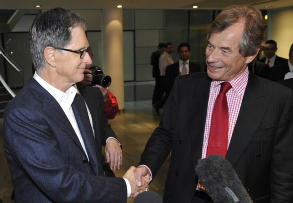 John Henry, left, the financier who heads New England Sports Ventures, owners of the Boston Red Sox, and  Liverpool's soccer club chairman Martin Broughton shake hands at a lawyers office in London, Friday, Oct. 15, 2010, where  Liverpool FC's club directors are meeting.