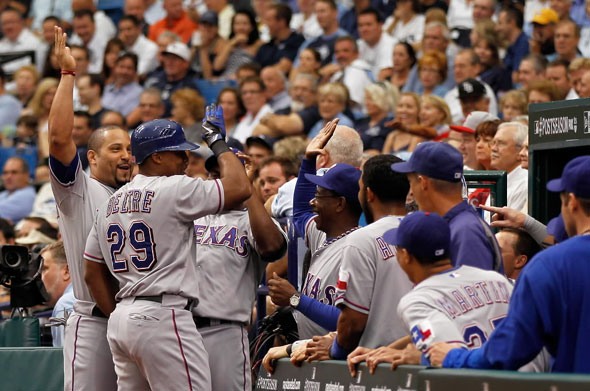 Adrian Beltre of the Texas Rangers celebrates with teammates and manager Ron Washington after Beltre hits a second inning solo home run off pitcher Jeremy Hellickson of the Tampa Bay Rays in Game Four of the American League Division Series at Tropicana Field on October 4, 2011