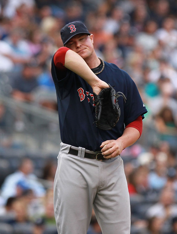 Jon Lester of the Boston Red Sox wipes sweat from his face against the New York Yankees on September 24, 2011 at Yankee Stadium in the Bronx borough of New York City.