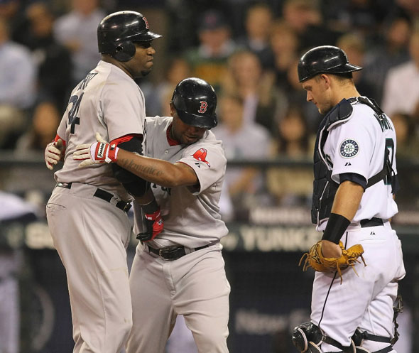 David Ortiz is hugged by Red Sox's Yamaico Navarro at the plate as Seattle Mariners catcher Adam Moore looks on