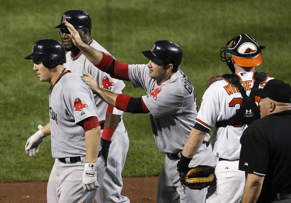 Ryan Lavarnway, left, walks away from home plate with teammates David Ortiz, second from left, and Adrian Gonzalez after Lavarnway drove the two in on a home run in the fourth inning of a baseball game against the Baltimore Orioles on Tuesday, Sept. 27, 2011, in Baltimore. At right is Orioles catcher Matt Wieters.